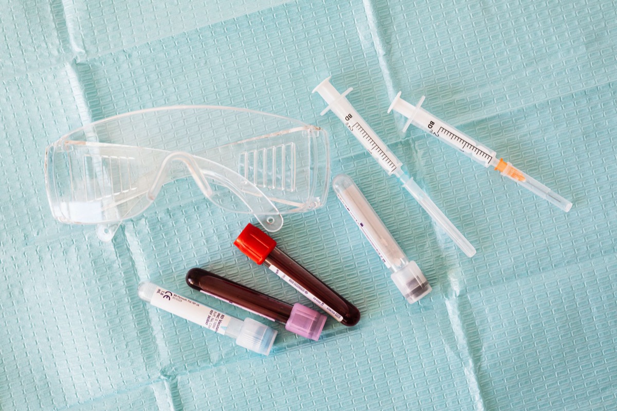 Medical syringe and vial with liquid in laboratory setting
