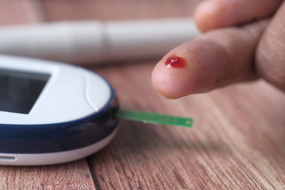 Close-up of a modern blood glucose meter displaying a stable reading