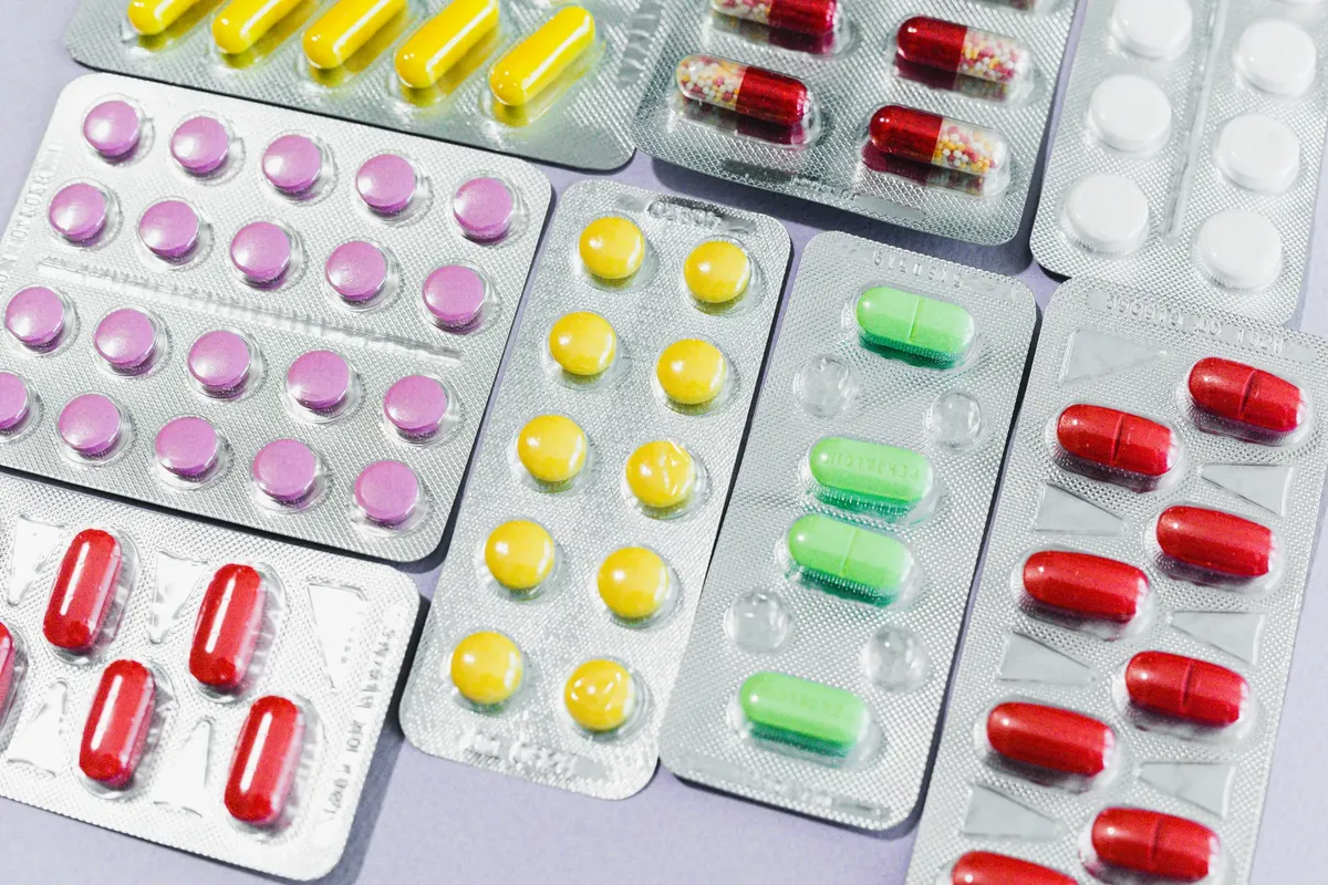 A variety of colorful pills and tablets in blister packs, representing diverse medication types.