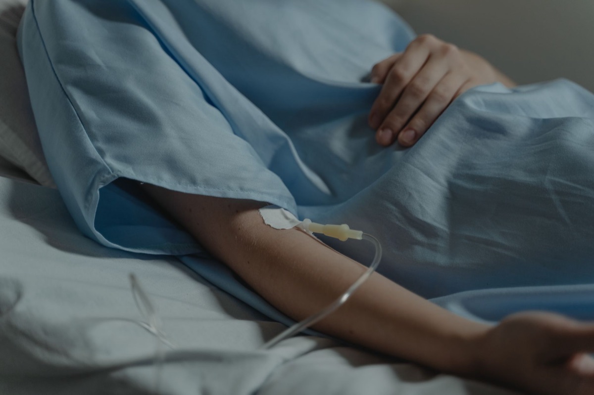 Hospital bed with nurse preparing IV drip
